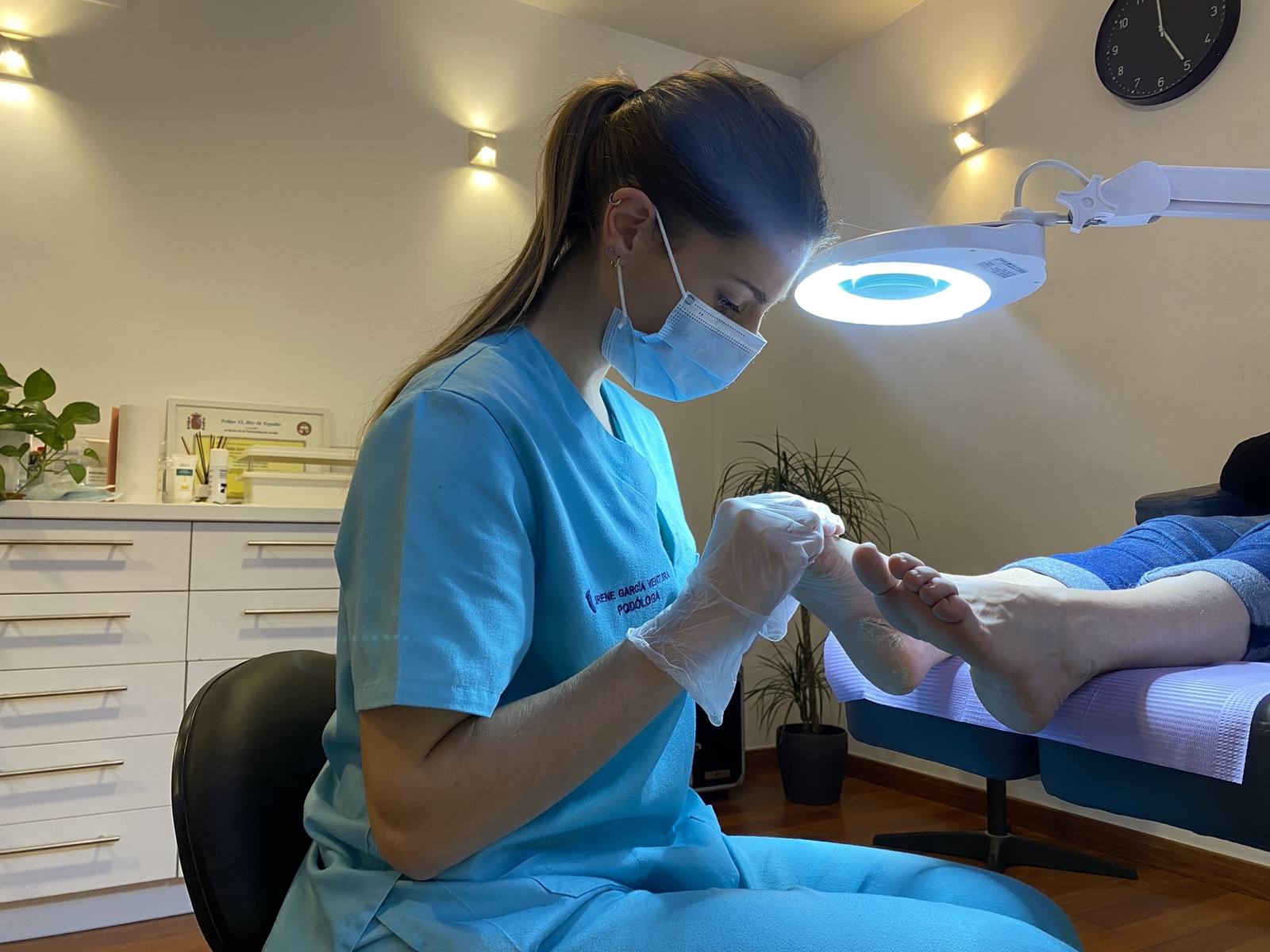 Irene García Ventura, podóloga colegiada, realizando quiropodia a una paciente en la Clínica Salud en Pie de Sevilla